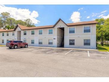 Tan colored building exterior with parking lot and landscaping at 415 Banana Cay Dr # F, South Daytona, FL 32119