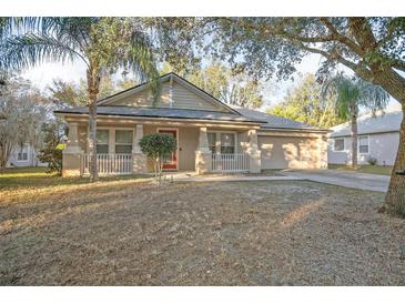 One-story house with red door, front porch, and landscaped yard at 1347 Pup Fish Ln, Deland, FL 32724