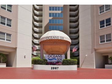 Oceans Six Condominium building entrance, featuring a covered walkway and landscaping at 2967 S Atlantic Ave # 204, Daytona Beach Shores, FL 32118