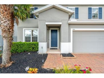 Front entrance with blue door and brick walkway at 3404 Grassy Lake View Ave, Minneola, FL 34715