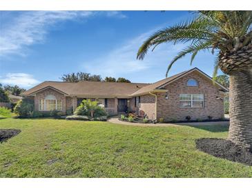 Charming brick home with landscaped yard and palm tree at 392 Glen Abbey Ln, Debary, FL 32713