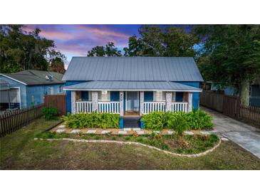 Charming blue cottage with metal roof, white trim, and landscaped front yard at 331 Sheldon St, New Smyrna Beach, FL 32168