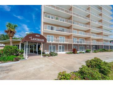 The Landmark building exterior with covered entryway and lush landscaping at 404 S Beach St # 010 101, Daytona Beach, FL 32114