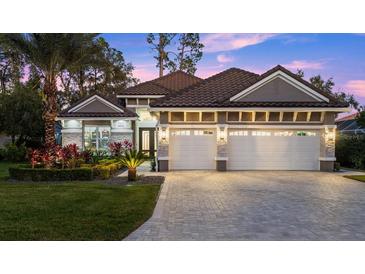 Luxury home exterior featuring a three-car garage and attractive landscaping at 437 Harbour Town Ln, Ormond Beach, FL 32174