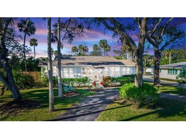 Charming bungalow with lush landscaping, a spacious yard, and a long driveway at 5178 Riverside Dr, Port Orange, FL 32127