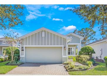 Single-story home with light gray siding, a two-car garage, and a nicely landscaped front yard at 430 Cypress Hills Way, Deland, FL 32724