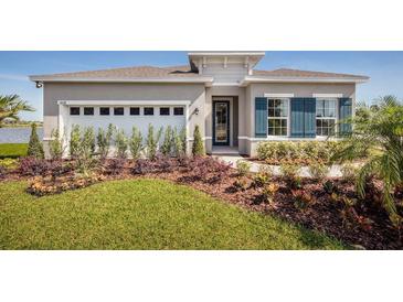 Gray house with blue shutters, two-car garage, and landscaped yard at 814 Canyon Creek Dr, New Smyrna Beach, FL 32168