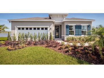 Two-story home with gray exterior, landscaped yard, and two-car garage at 1897 Basenji Dr, Lake Alfred, FL 33850