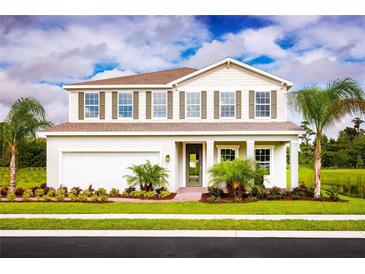 Two-story house with a white exterior, landscaped lawn, and palm trees at 1299 Whispering Ln, Minneola, FL 34715