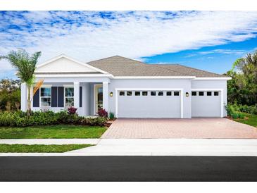 Single-story home with two-car garage, attractive landscaping, and a brick driveway at 2193 Aibonito Cir, Clermont, FL 34711