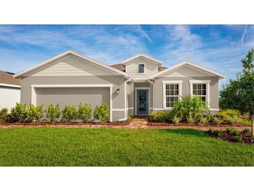 Single-story home with gray siding, landscaping, and a brick walkway at 10937 Sw 73Rd Ct, Ocala, FL 34476