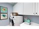 Bright laundry room with washer, dryer, and white cabinets at 1341 Arklow Cir, Ormond Beach, FL 32174