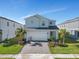 Two-story house with a gray exterior, gray driveway, and landscaping at 2201 Lelani Cir, Davenport, FL 33897