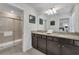 Double vanity bathroom with granite countertops and a large shower at 2201 Lelani Cir, Davenport, FL 33897