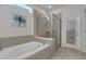 Relaxing bathroom with soaking tub, shower, and neutral tile at 2201 Lelani Cir, Davenport, FL 33897