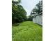 Overgrown backyard with tall grass and partially constructed home at 1134 N Davis Ave, Lakeland, FL 33805