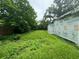 Overgrown backyard with tall grass and a partially constructed home at 1134 N Davis Ave, Lakeland, FL 33805