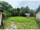 Overgrown backyard with a small structure and tall grass at 1134 N Davis Ave, Lakeland, FL 33805