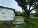 Backyard with overgrown grass, a large tree, and a partially constructed home at 1134 N Davis Ave, Lakeland, FL 33805