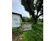 Backyard with overgrown grass, a large tree, and a partially constructed home at 1134 N Davis Ave, Lakeland, FL 33805