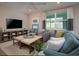 Living Room with teal couch and large TV at 177 Bella Verano Way, Davenport, FL 33897