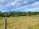 Open pasture with a wooden fence and distant trees at 850 Eden Dr, Saint Cloud, FL 34771