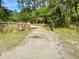 Gravel driveway leading to a gated property with trash cans at 850 Eden Dr, Saint Cloud, FL 34771