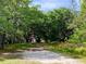 Long driveway leading to a red barn nestled amongst trees at 850 Eden Dr, Saint Cloud, FL 34771