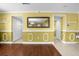 A bright hallway with yellow walls, white trim, and wood flooring at 11407 Bentry St, Orlando, FL 32824