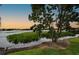 Scenic lake view at sunset, showcasing tranquil waters and vegetation at 1502 Ne Buckeye Ne Rd # 2, Winter Haven, FL 33881