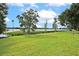 Serene lakefront landscape with mature trees and grassy area at 1502 Ne Buckeye Ne Rd # 2, Winter Haven, FL 33881