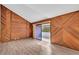 Large bedroom with wood-paneled walls and access to balcony at 1502 Ne Buckeye Ne Rd # 2, Winter Haven, FL 33881