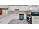 Updated kitchen featuring white cabinets, stainless steel appliances, and L-shaped counters at 1502 Ne Buckeye Ne Rd # 2, Winter Haven, FL 33881