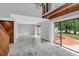 Spacious living room with wood-paneled wall and access to patio at 1502 Ne Buckeye Ne Rd # 2, Winter Haven, FL 33881