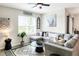 Spacious living room with L-shaped sectional sofa, a large TV, and a ceiling fan at 2638 Galway Grove Way, Lakeland, FL 33811