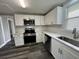 Updated kitchen with white cabinets and stainless steel appliances at 2808 Fletcher Ave, Lakeland, FL 33803