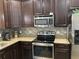 Kitchen with stainless steel appliances and dark wood cabinets at 516 Juniper Springs Dr, Groveland, FL 34736