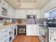 White kitchen cabinets, wood-look flooring, and appliances at 5337 Jacob Ave, Polk City, FL 33868