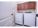 Bright laundry room with washer, dryer, and overhead cabinets at 7036 Mapperton Dr, Windermere, FL 34786