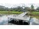 Wooden dock with seating on a calm lake in a residential community at 7036 Mapperton Dr, Windermere, FL 34786