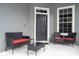 Front porch with black wicker furniture and red cushions at 7036 Mapperton Dr, Windermere, FL 34786
