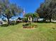 Landscaped front yard with mature trees and circular garden at 24502 Parlange Ct, Leesburg, FL 34748