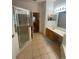 Bathroom with shower, double vanity, and access to another room at 24502 Parlange Ct, Leesburg, FL 34748