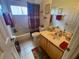 Clean bathroom with tub shower combo and wood vanity at 24502 Parlange Ct, Leesburg, FL 34748