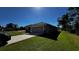 View of the home's garage and driveway, surrounded by a well-maintained lawn at 9832 Sw 46Th Ct, Ocala, FL 34476