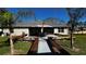 Spacious backyard patio with wooden benches, an umbrella, and lush landscaping at 9832 Sw 46Th Ct, Ocala, FL 34476