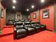 Home theater room with tiered seating and a large projection screen at 550 Muirfield Loop, Reunion, FL 34747