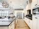 Modern kitchen with white cabinets, stainless steel appliances and a large island at 550 Muirfield Loop, Reunion, FL 34747