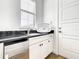 Clean laundry room with sink, cabinets and a side door at 550 Muirfield Loop, Reunion, FL 34747