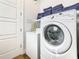 Bright laundry room with washer, dryer and storage shelves at 550 Muirfield Loop, Reunion, FL 34747